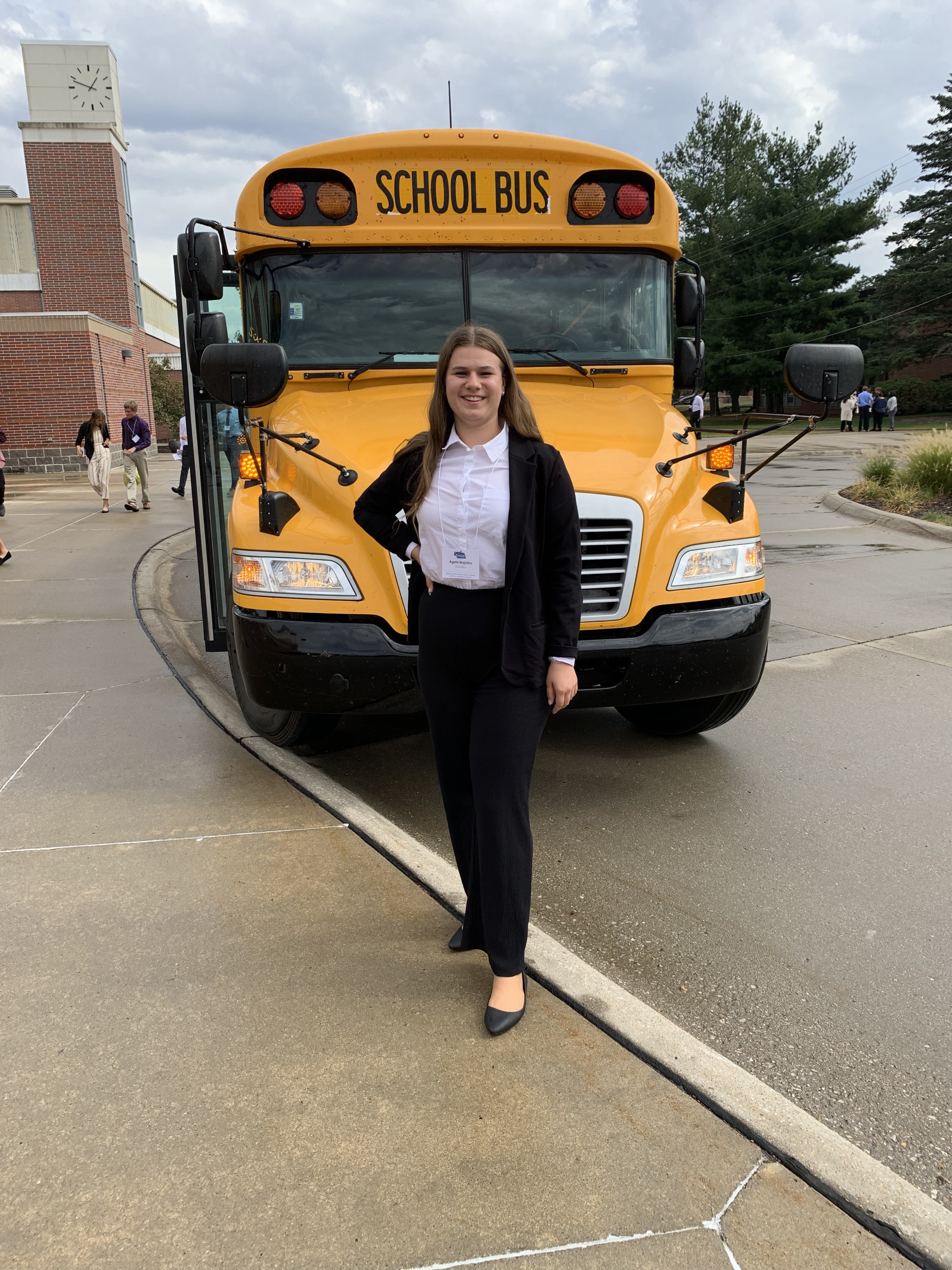 Agata from Poland smiling in front of a school bus