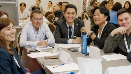 C5+O.N.E. Program Participants Smiling at Conference Brainstorm Session