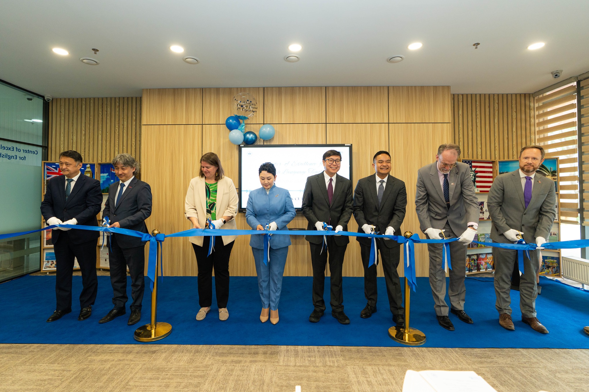 US Embassy Ulaanbaatar_ COE Ribbon Cutting_ 8 Embassy Staff cut blue ribbon at US Embassy Mongolia 