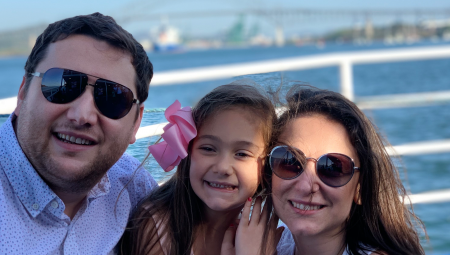 Ambassador Rudi, her husband, and daughter, smiling at the camera from the deck of a boat crossing the Panama Canal